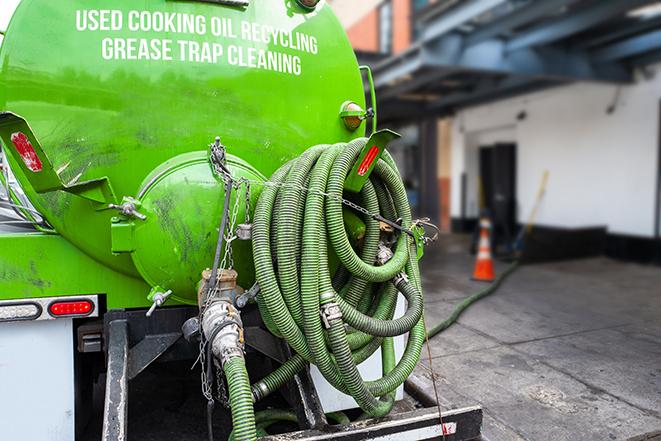 a technician pumping a grease trap in a commercial building in Dahlonega